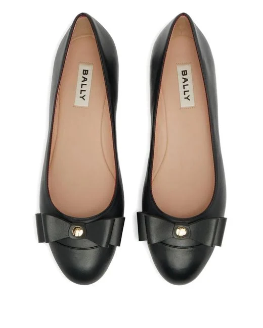 A pair of black leather Bally ballet flats seen from above, showing the BALLY label and the red and white striped lining.