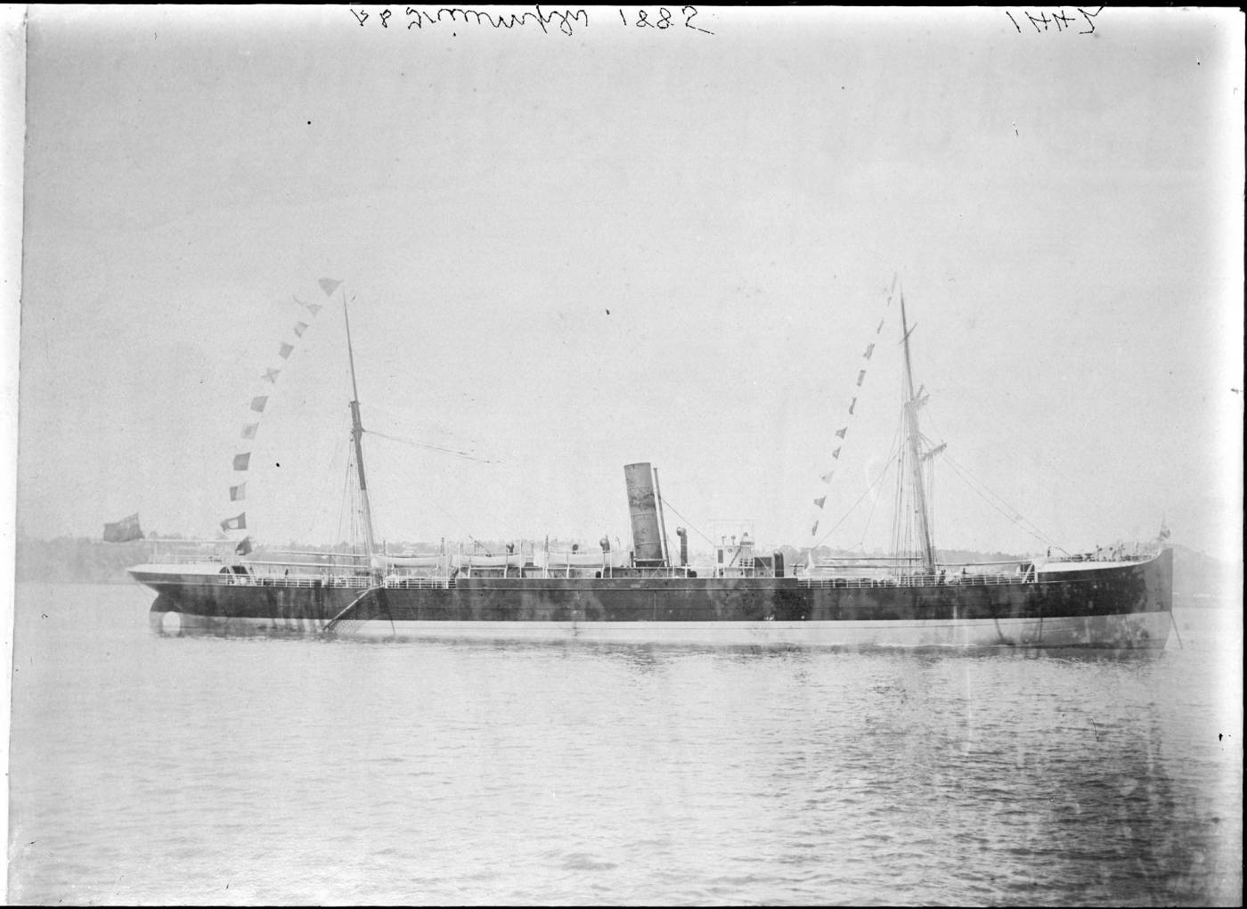 The <em>Hilonian</em> under her first name, <em>Triumph</em>, repaired and dressed in flags in Auckland harbour, 1884. Auckland Libraries Heritage Collections 4-1442 (no known copyright restrictions).
