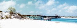 As best I can tell from the map of Wake Island this is the bridge between Wake Island and Peale Island. The water beneath leads into the lagoon. It appears that the bridge is under construction. I think this photo --- actually two slides stitched together --- is circa 1953.