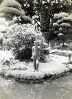 Craig standing in the old Queen's Surf gardens, Waikiki Beach, 1958. Complete with the tiki in the background.